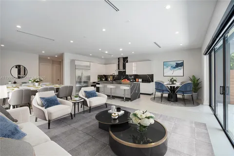 a living room with furniture and a dining table with kitchen view