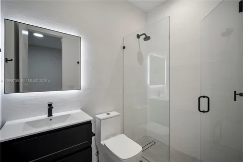 a bathroom with a sink toilet and a mirror