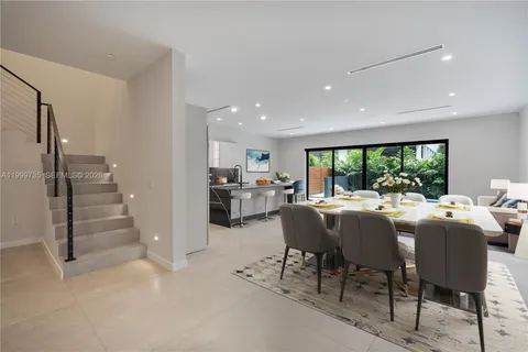 a dining room with furniture and a floor to ceiling window