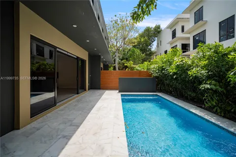 a view of backyard with potted plants and floor to ceiling window