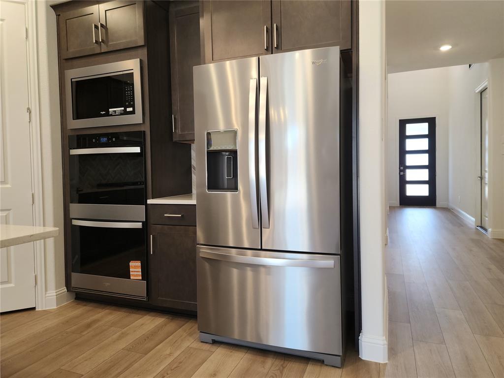 2433 Glacier Ridge Corinth, TX 76210 - Photo 13 of 40 a metallic refrigerator freezer sitting in a kitchen
