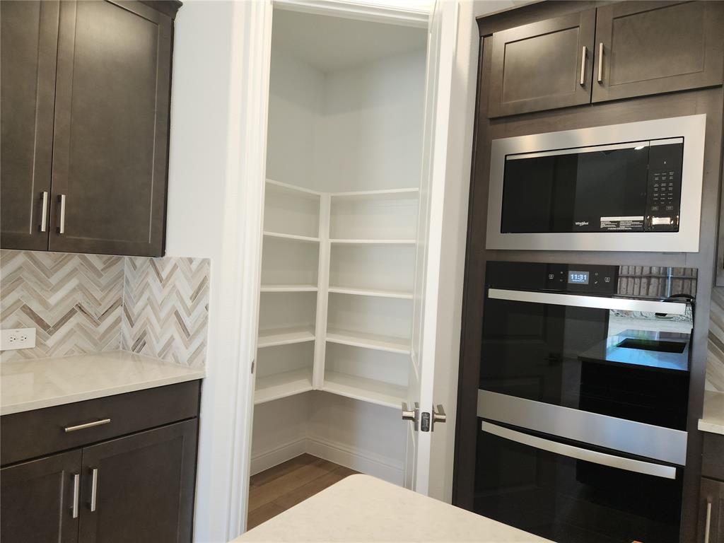 2433 Glacier Ridge Corinth, TX 76210 - Photo 14 of 40 a kitchen with a stove and a microwave