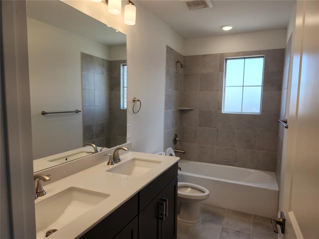 2433 Glacier Ridge Corinth, TX 76210 - Photo 36 of 40 a bathroom with a granite countertop sink toilet and shower