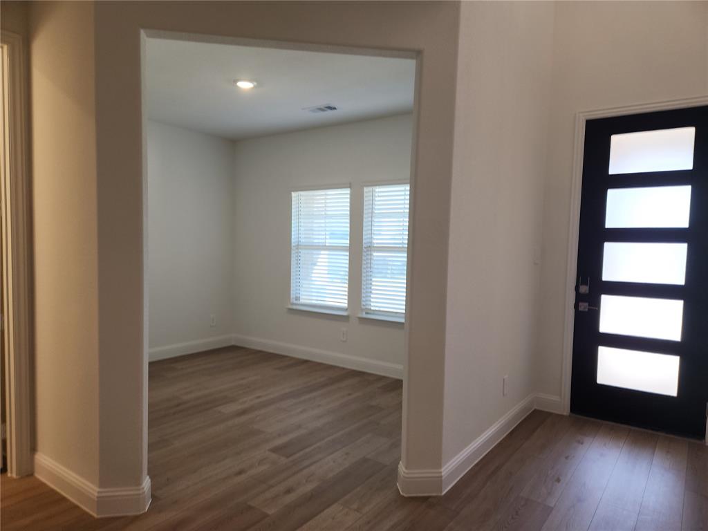 2433 Glacier Ridge Corinth, TX 76210 - Photo 7 of 40 an empty room with wooden floor and windows