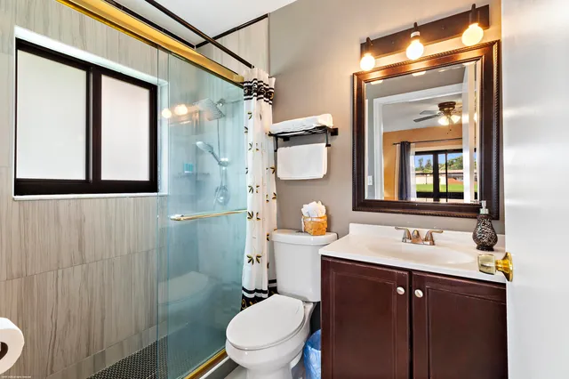 a bathroom with a sink vanity mirror and toilet