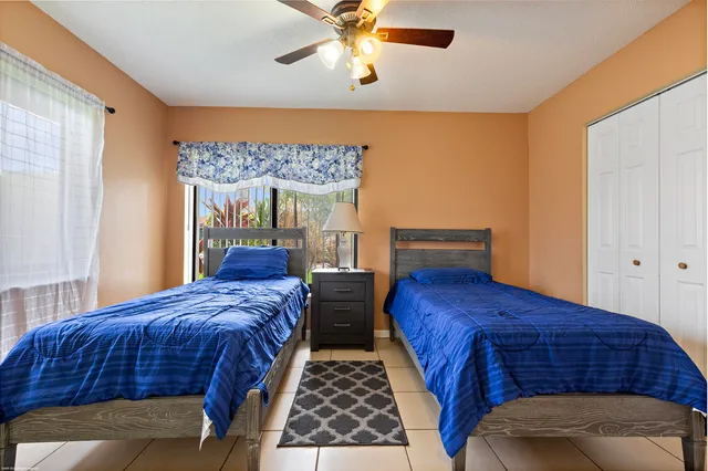 a bedroom with two beds and window