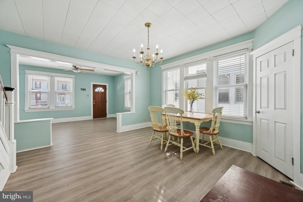 525 Bridgeboro Street Riverside, NJ 08075 - Photo 3 of 16 a dining room with wooden floor a chandelier a wooden table and chairs