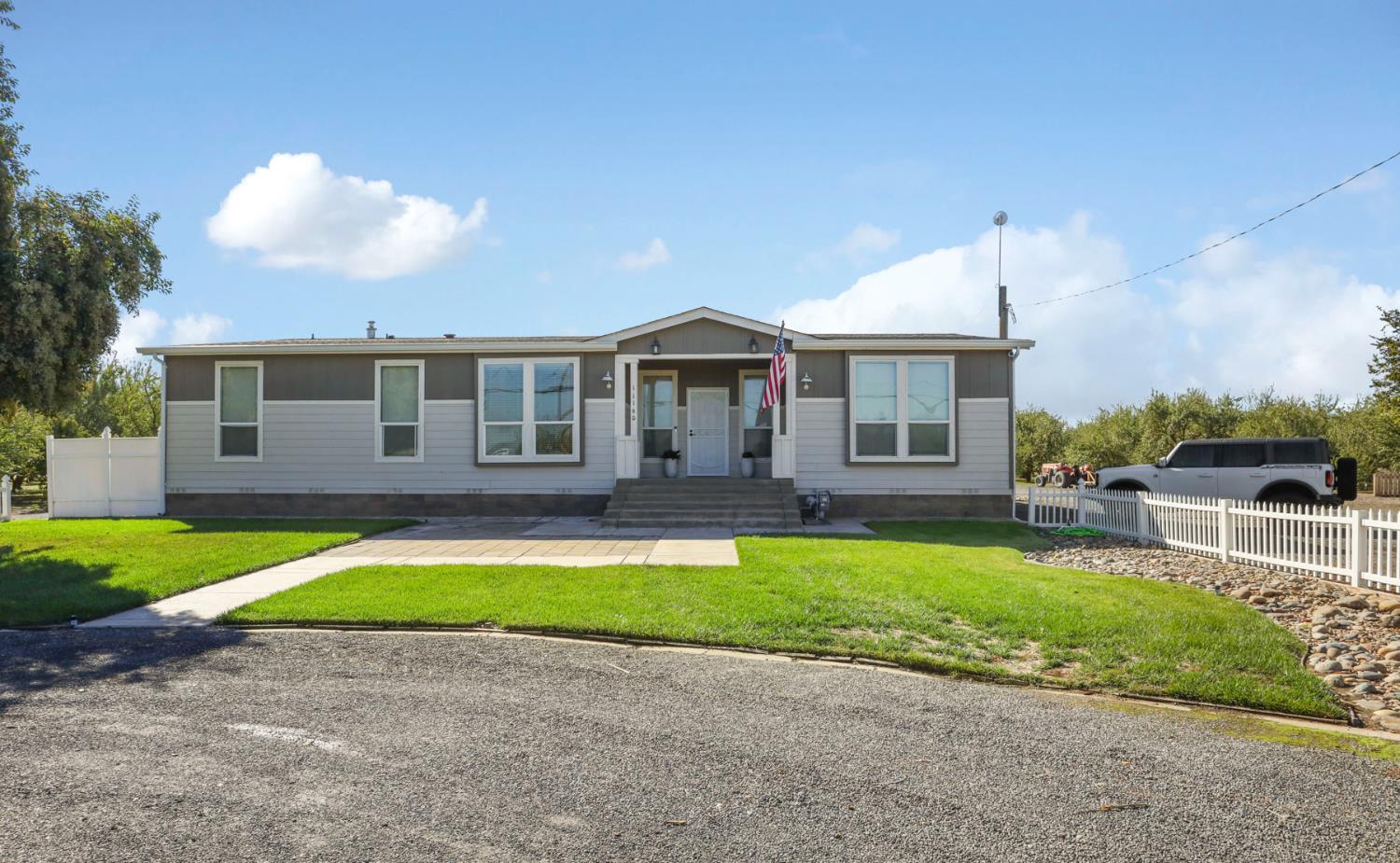 11132 West Ripon Road Ripon, CA 95366 - Photo 1 of 1 a front view of a house with a yard and porch