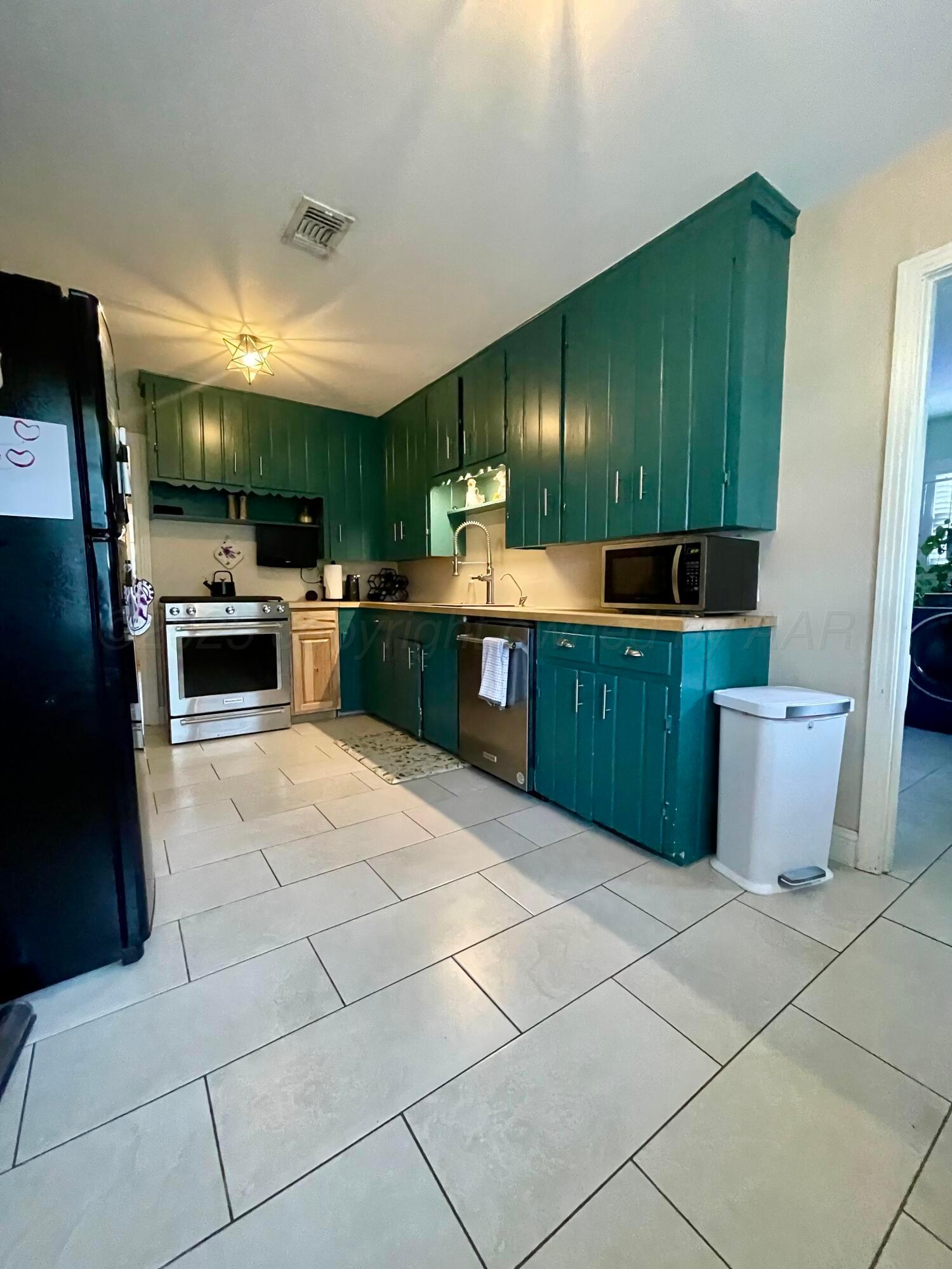 2406 Juniper Drive Amarillo, TX 79109 - Photo 11 of 28 a large kitchen with kitchen island a stove a sink dishwasher and a refrigerator