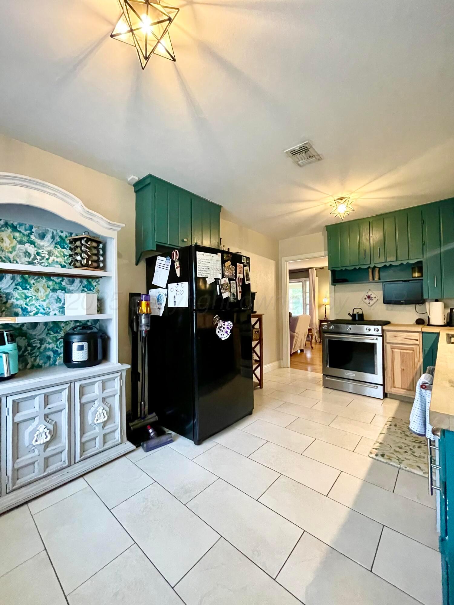 2406 Juniper Drive Amarillo, TX 79109 - Photo 10 of 28 a kitchen with granite countertop a refrigerator and a stove top oven