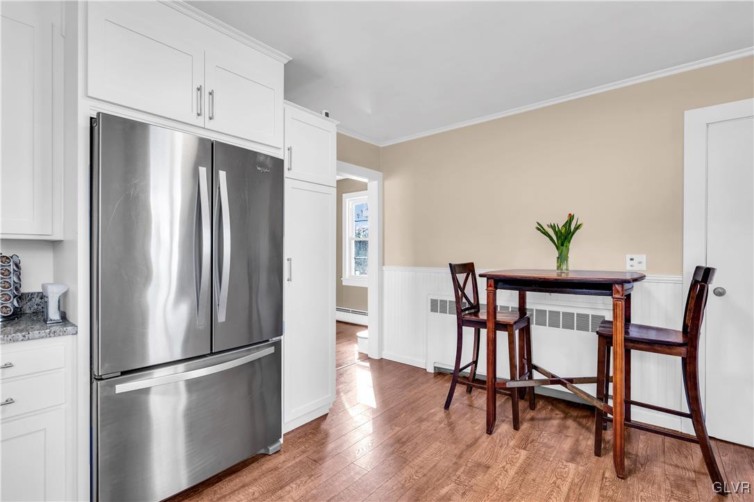 975 State Park Road Wind Gap, PA 18091 - Photo 5 of 17 a kitchen with stainless steel appliances a refrigerator a stove a dining table and chairs with wooden floor