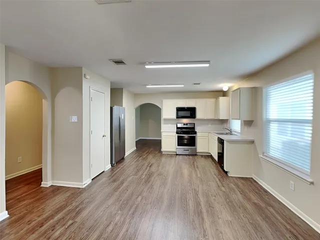 a view of kitchen with wooden floor and electronic appliances