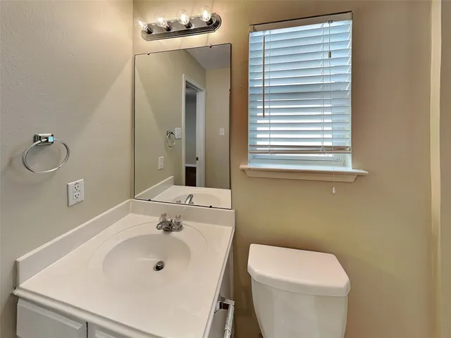 a bathroom with a sink a toilet and mirror