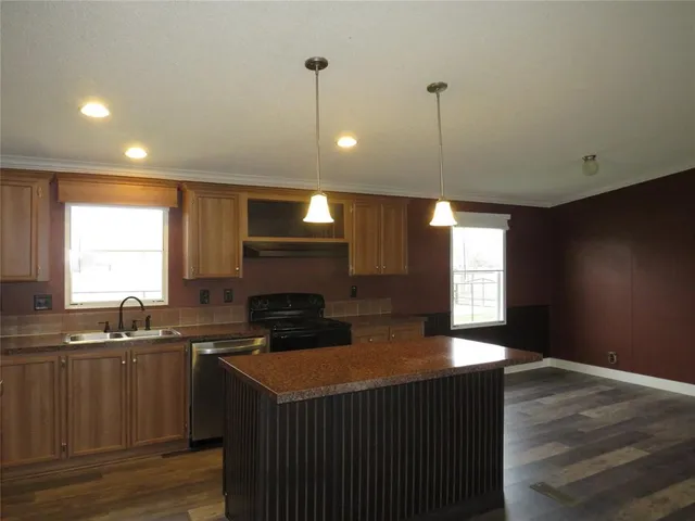 a kitchen with granite countertop a sink a counter space appliances and cabinets
