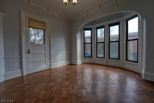 an empty room with wooden floor and a window