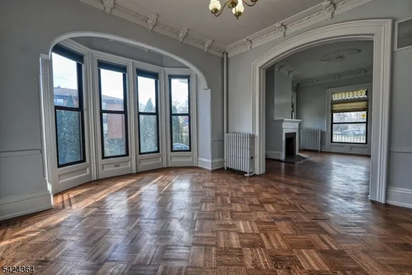 en empty room with window and wooden floor
