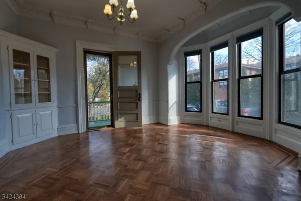 a view of an empty room with glass door and wooden floor