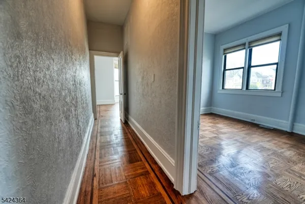 a view of a hallway with wooden floor and staircase