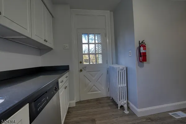 a kitchen with cabinets and wooden floor