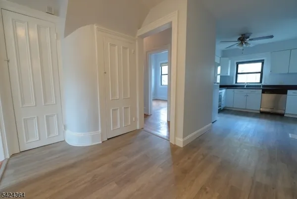 a view of a kitchen with wooden floor and a window