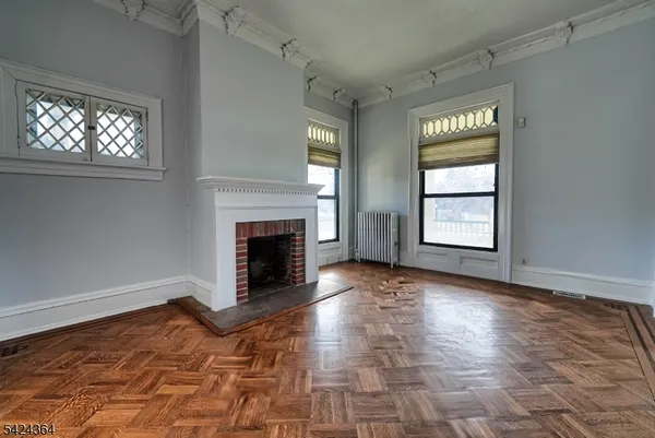 an empty room with windows and fireplace