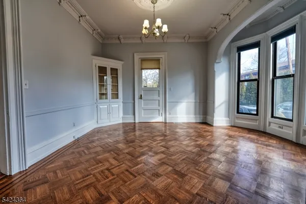 a view of an empty room with a windows and a chandelier