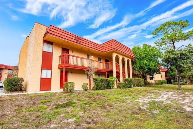 a view of a swimming pool with a yard and trees in the background