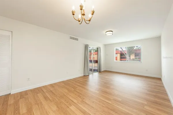 an empty room with wooden floor and window