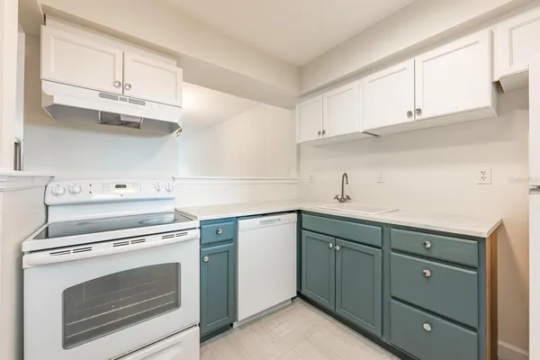 a kitchen with a stove sink and cabinets