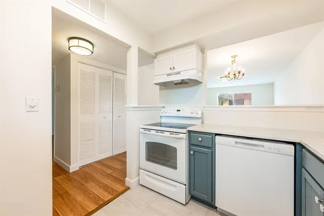 an empty room with wooden floor closet and windows