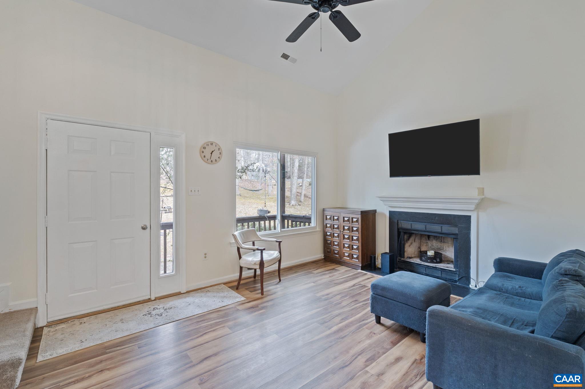 473 Larkspur Road Ruckersville, VA 22968 - Photo 4 of 28 a living room with furniture a fireplace and a flat screen tv