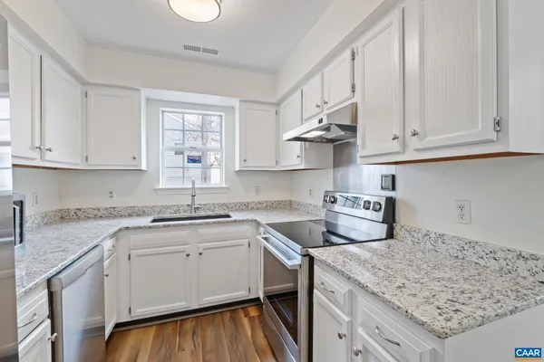 a kitchen with stainless steel appliances granite countertop a sink refrigerator and cabinets