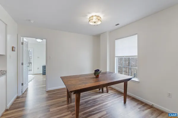 a kitchen with stainless steel appliances granite countertop a sink dishwasher and a refrigerator with wooden floor