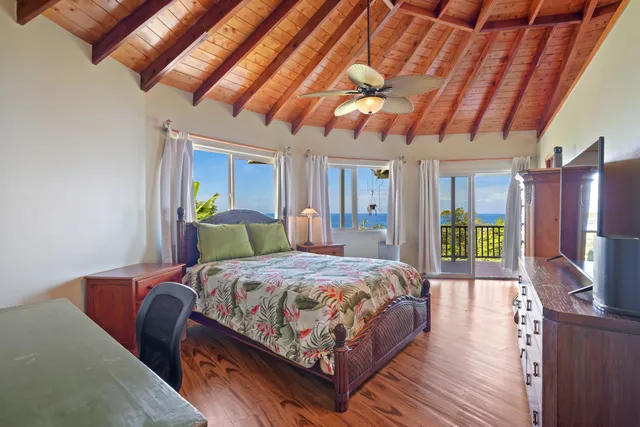 a bedroom with a bed a dresser with wooden floor