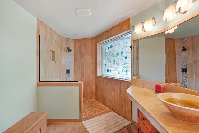 a bathroom with a tub a sink and a mirror