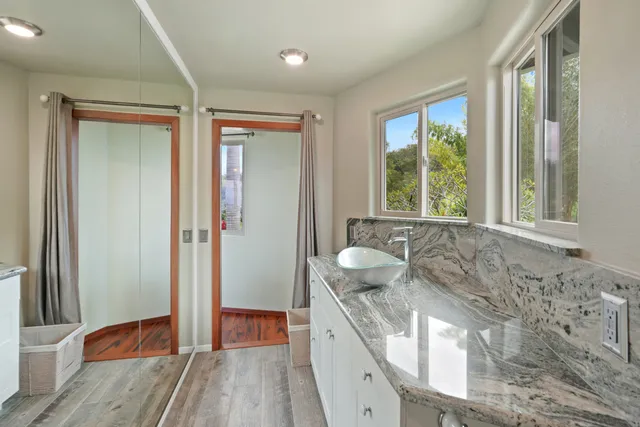 a spacious bathroom with a granite countertop sink a toilet and a large mirror
