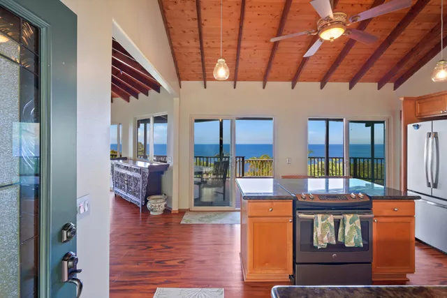 a living room with furniture floor to ceiling window and wooden floor