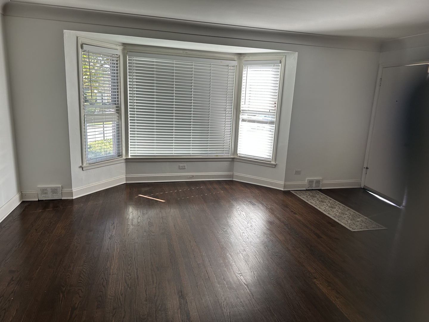 6204 North Troy Street, Unit 1 Chicago, IL 60659 - Photo 3 of 8 an empty room with wooden floor and windows
