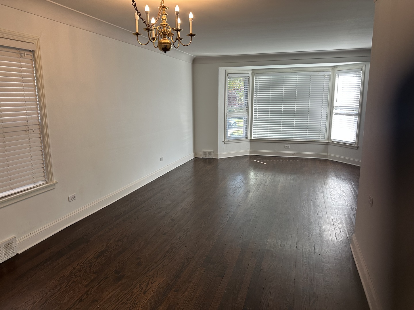 6204 North Troy Street, Unit 1 Chicago, IL 60659 - Photo 5 of 8 a view of an empty room with wooden floor and a window