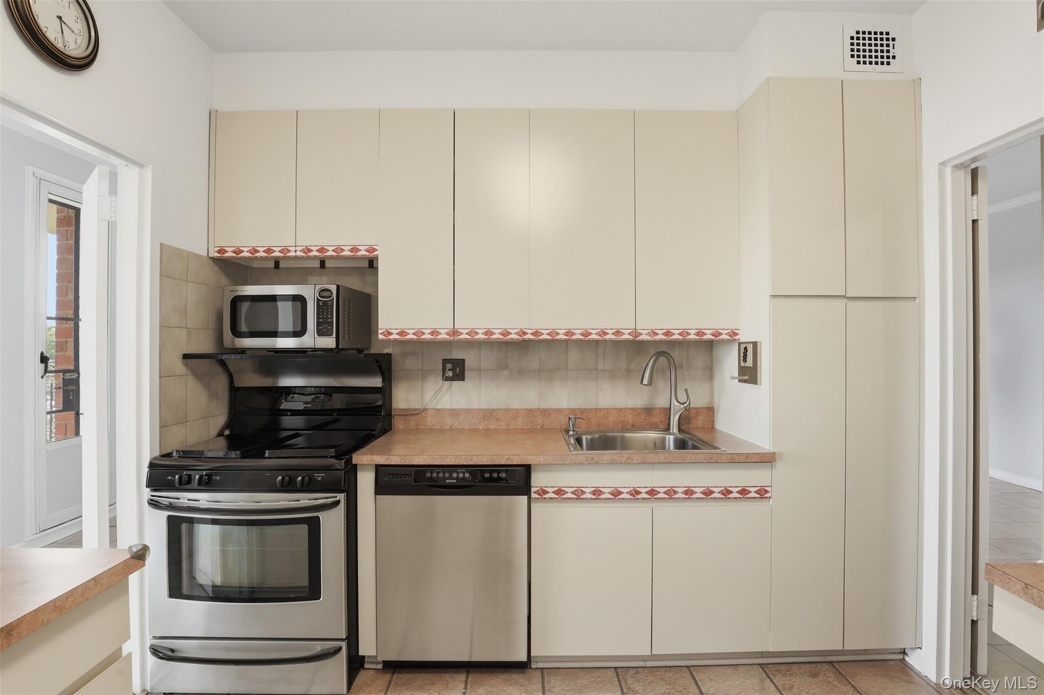 16 Rockledge Avenue, Unit 2C1 Ossining, NY 10562 - Photo 11 of 48 a kitchen with stainless steel appliances a stove a microwave and a refrigerator