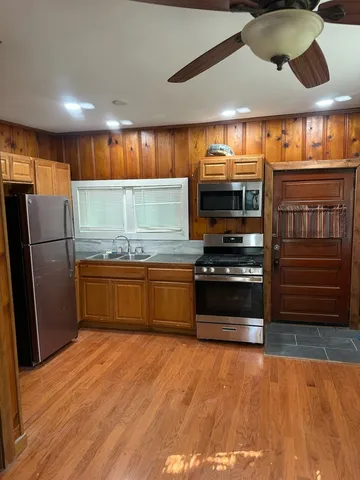 a kitchen with stainless steel appliances kitchen island granite countertop a refrigerator and a stove