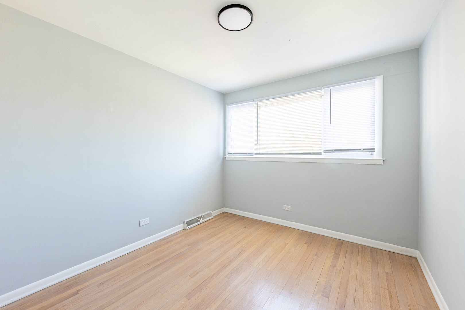 4914 West 32nd Place, Unit 2 Cicero, IL 60804 - Photo 14 of 26 an empty room with wooden floor and windows