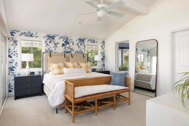 a bedroom with a large bed and a flat tv screen on the dresser