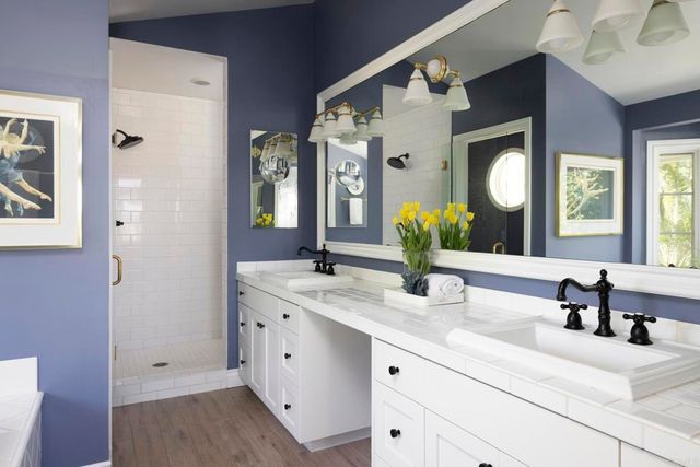 a white bath tub sitting in a bathroom next to a window