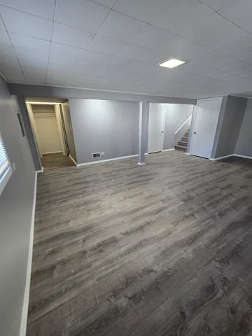 a view of empty room with wooden floor