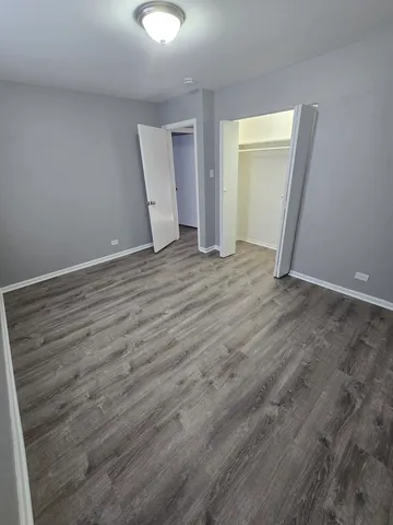 an empty room with wooden floor and mirror