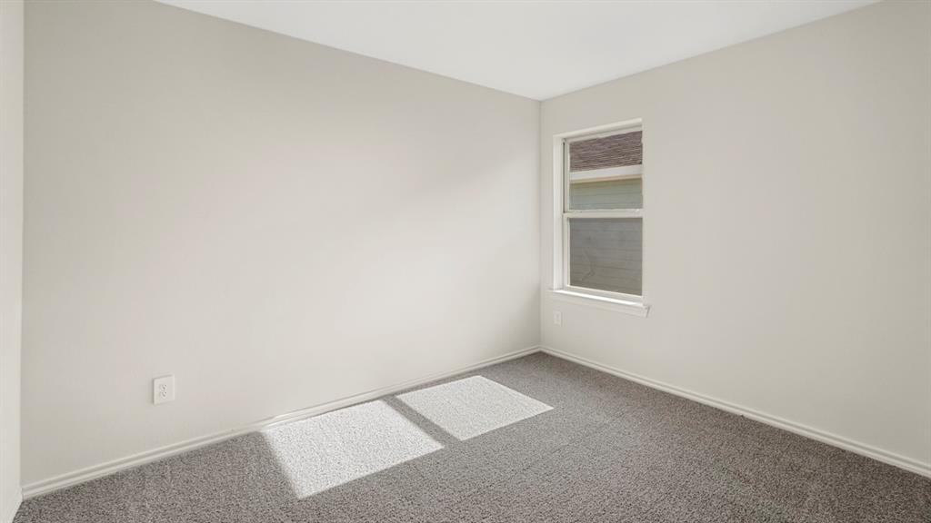 1969 Freeman Street Tyler, TX 75704 - Photo 21 of 30 Neutral-toned room featuring a single window with white trim, light gray wall paint, and plush gray carpeting