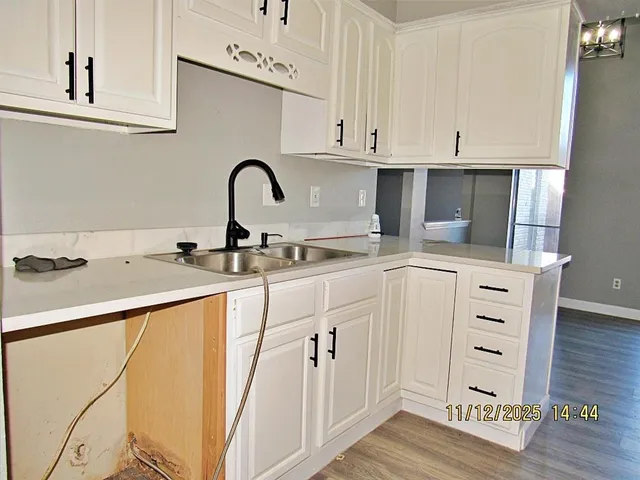 a kitchen with cabinets appliances and a wooden floor