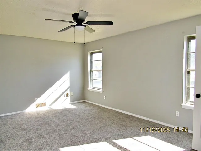 a view of a livingroom with a ceiling fan and window