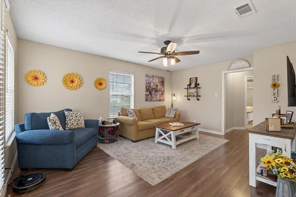 a living room with furniture and wooden floor